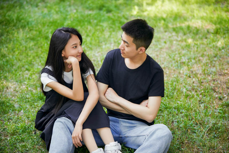 户外草坪上的恩爱年轻情侣图片