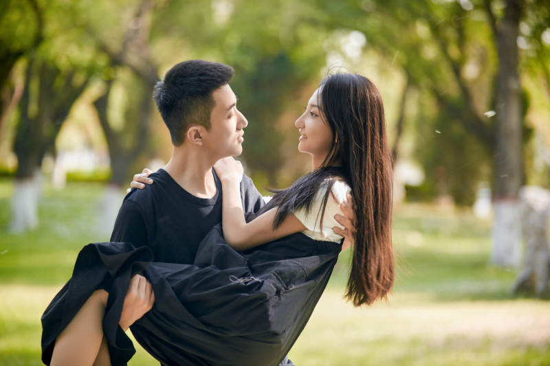 户外草坪上的恩爱年轻情侣图片