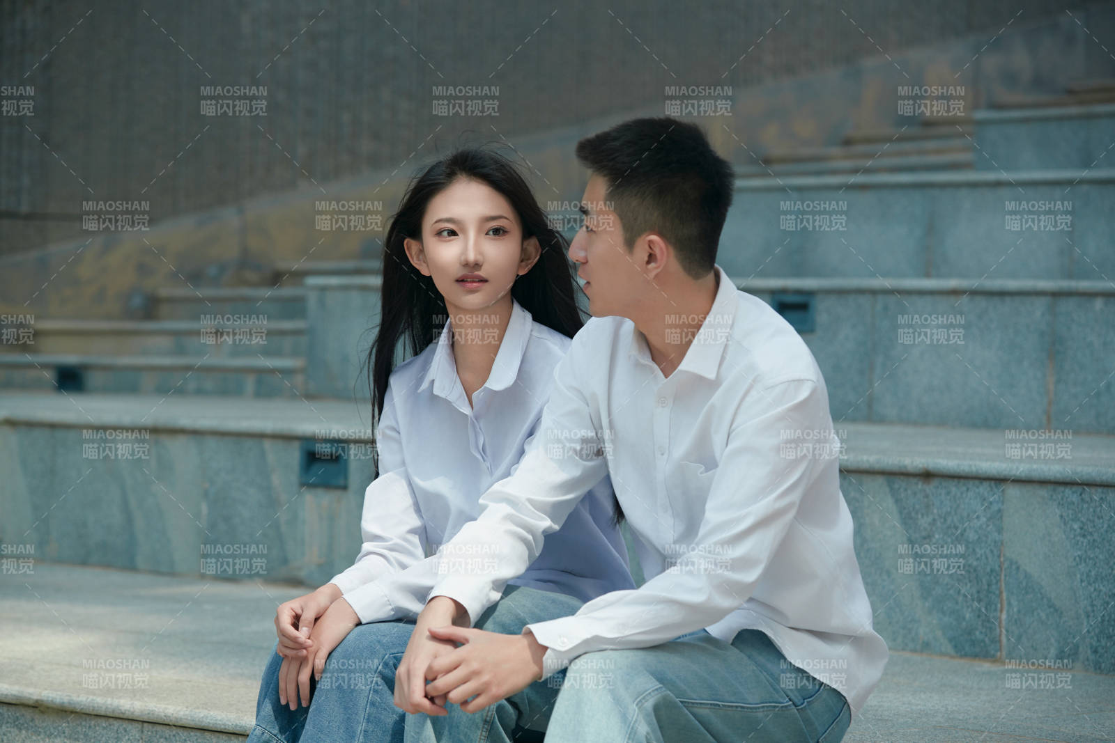 坐在户外台阶上的青年情侣图片