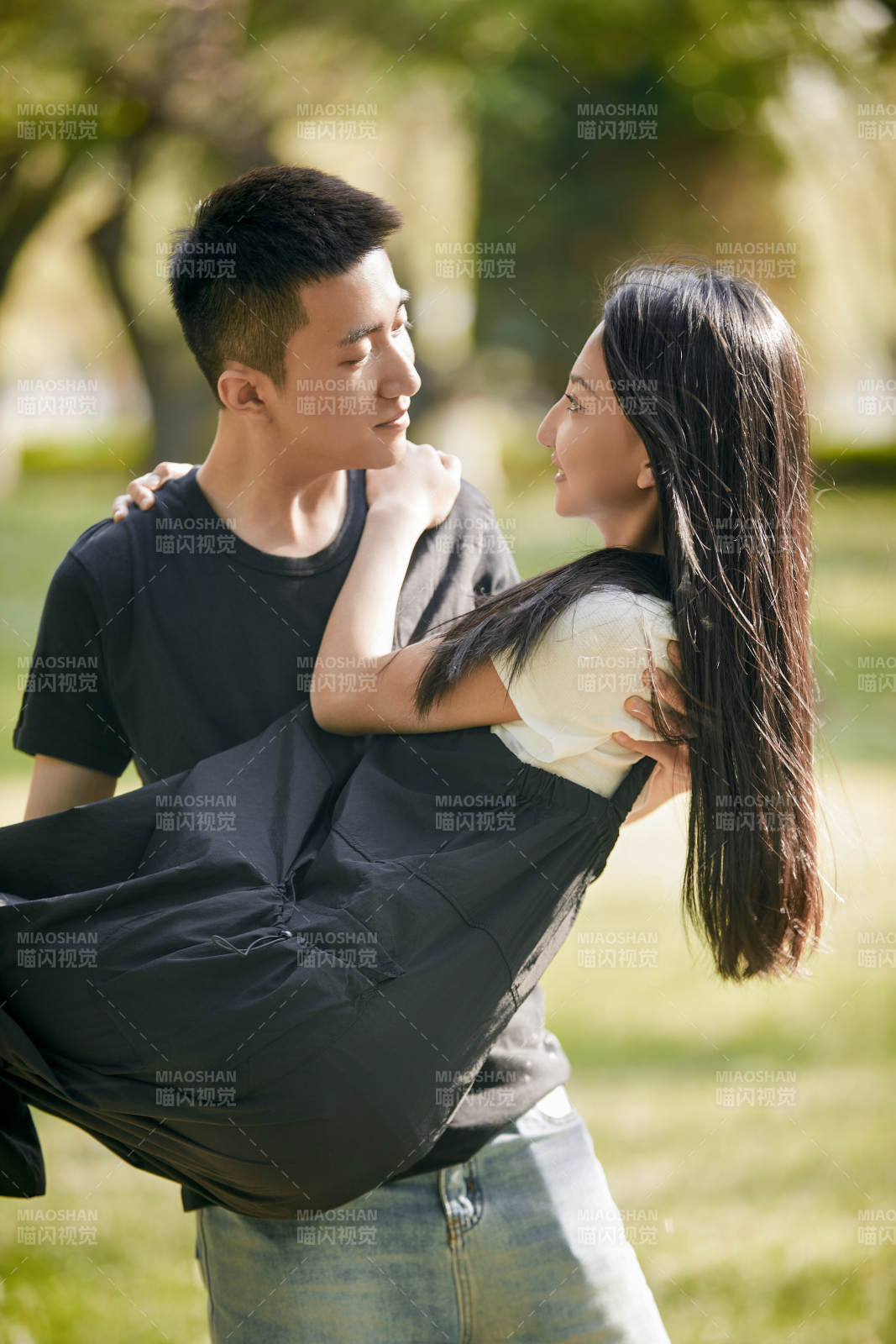 户外草坪上的恩爱年轻情侣图片