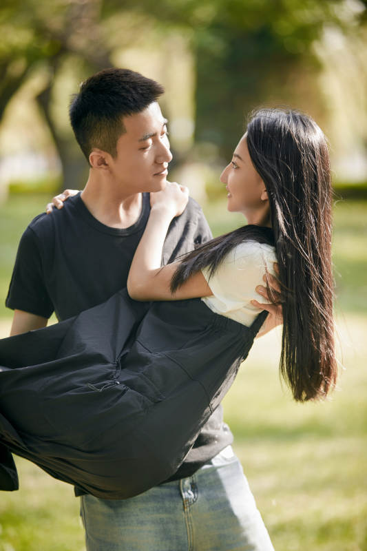 户外草坪上的恩爱年轻情侣图片