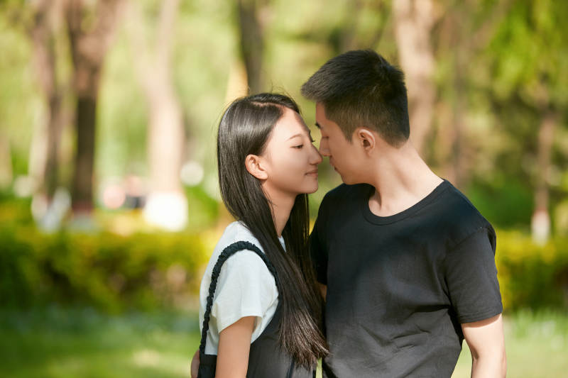 户外草坪上的恩爱年轻情侣图片