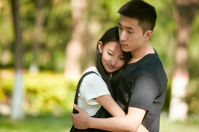 户外草坪上的恩爱年轻情侣图片