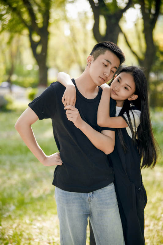 户外草坪上的恩爱年轻情侣图片