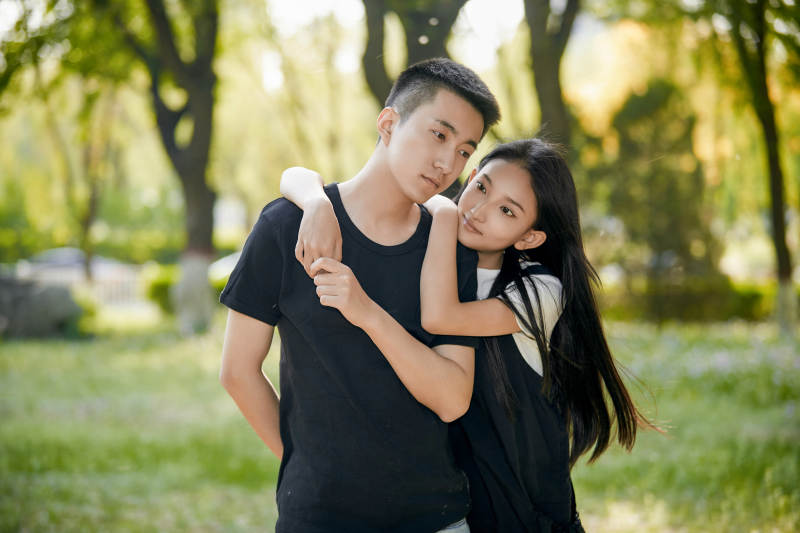 户外草坪上的恩爱年轻情侣图片