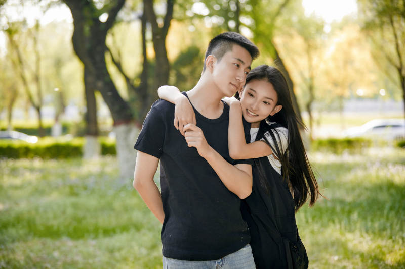 户外草坪上的恩爱年轻情侣图片