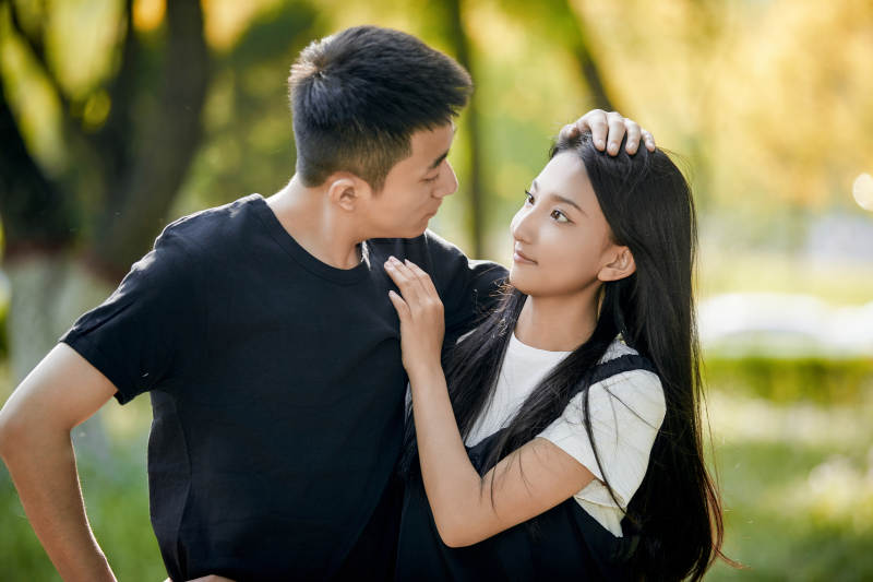 户外草坪上的恩爱年轻情侣图片