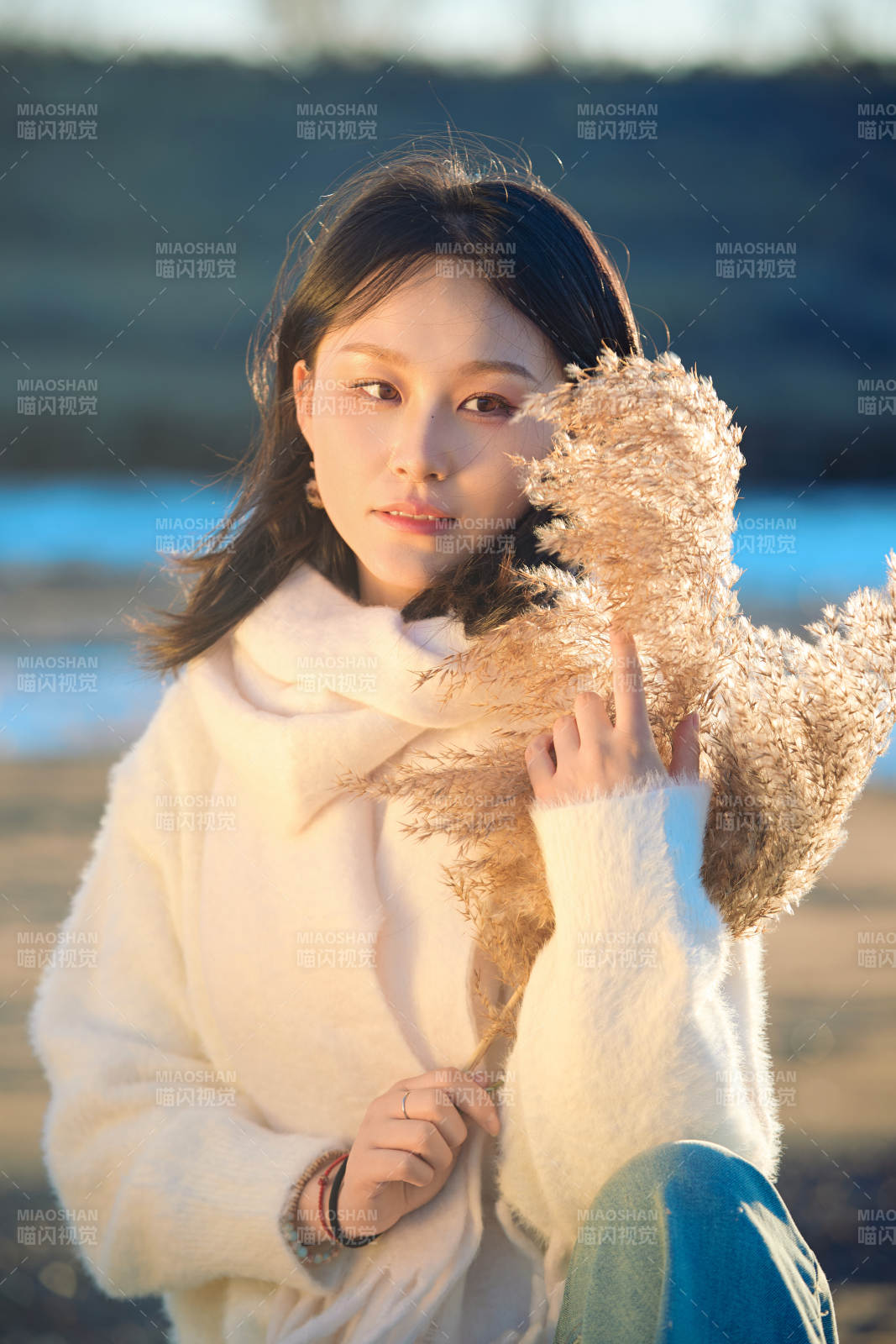 秋天在夕阳下的原野河边拍照的美女图片