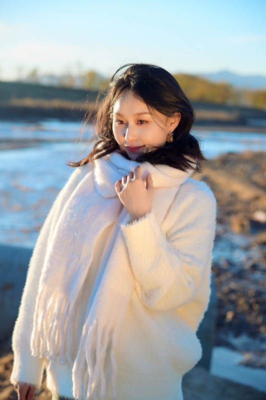 秋天在夕阳下的原野河边拍照的美女图片