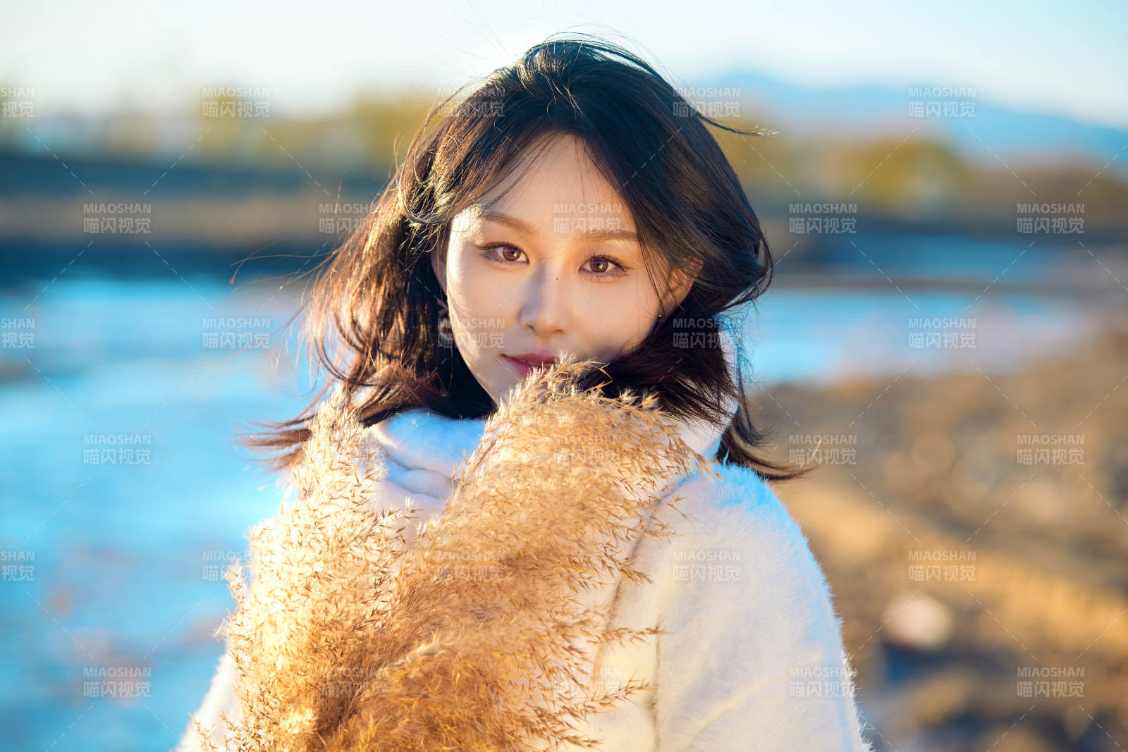 秋天在夕阳下的原野河边拍照的美女图片