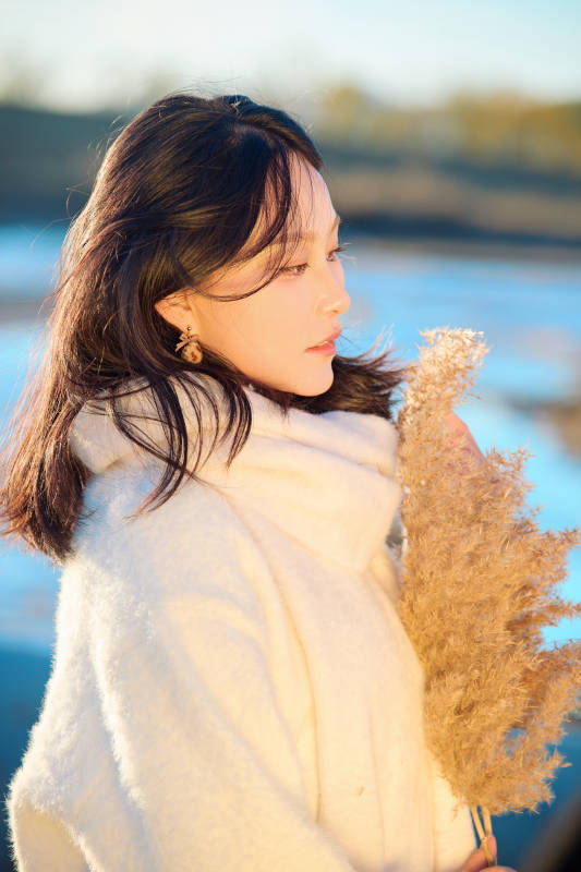 秋天在夕阳下的原野河边拍照的美女图片