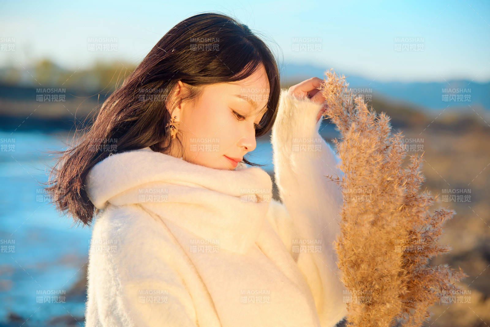秋天在夕阳下的原野河边拍照的美女图片