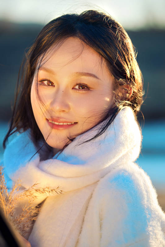 秋天在夕阳下的原野河边拍照的美女图片