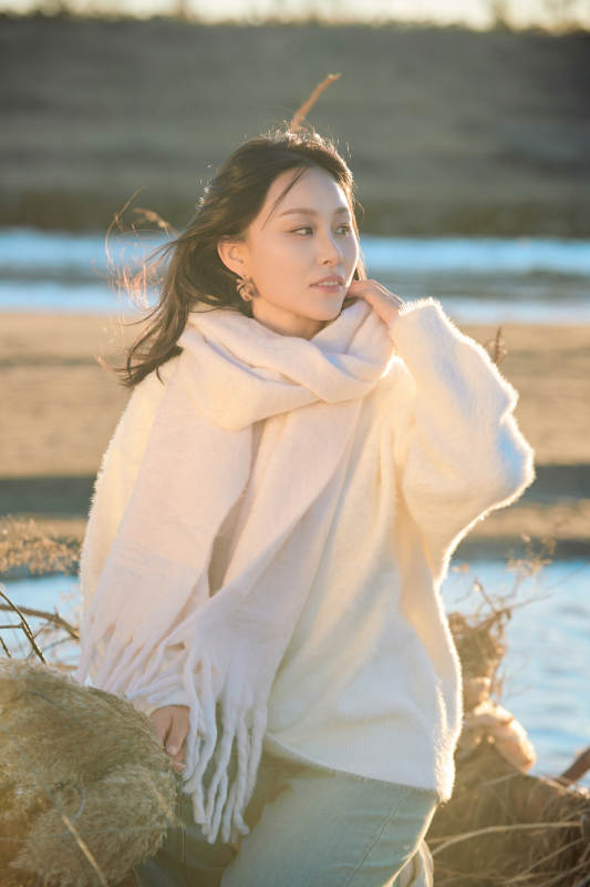 秋天在夕阳下的原野河边拍照的美女图片