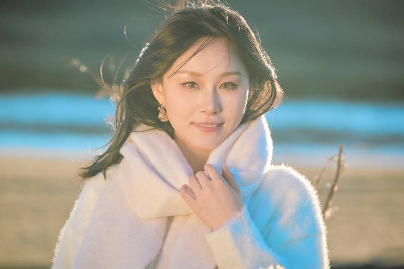 秋天在夕阳下的原野河边拍照的美女图片