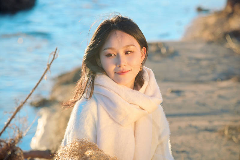 秋天在夕阳下的原野河边拍照的美女图片