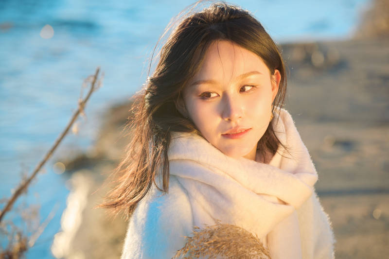 秋天在夕阳下的原野河边拍照的美女图片