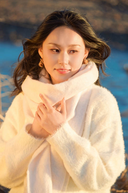 秋天在夕阳下的原野河边拍照的美女图片