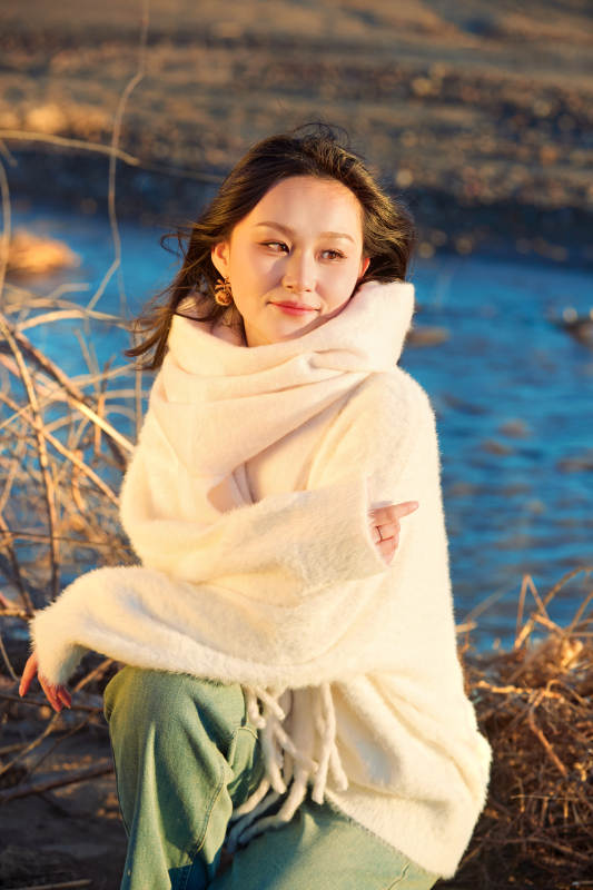 秋天在夕阳下的原野河边拍照的美女图片