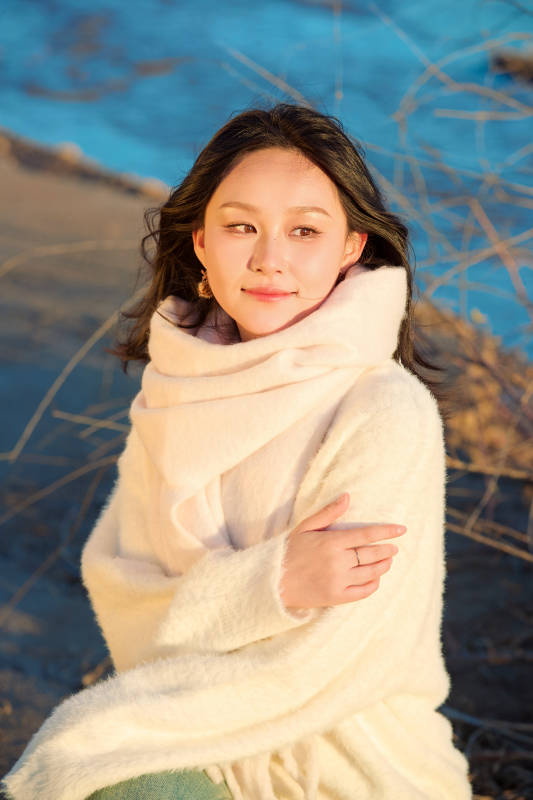 秋天在夕阳下的原野河边拍照的美女图片