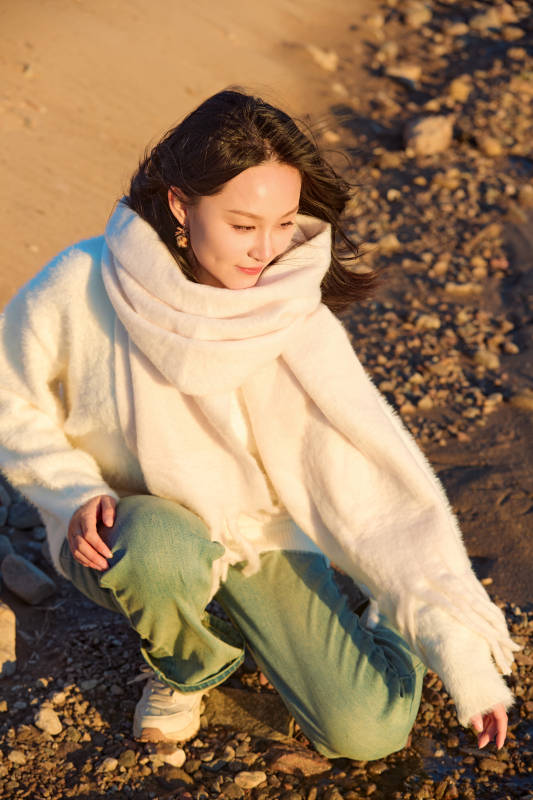 深秋夕阳下在户外河水边的东方女性图片