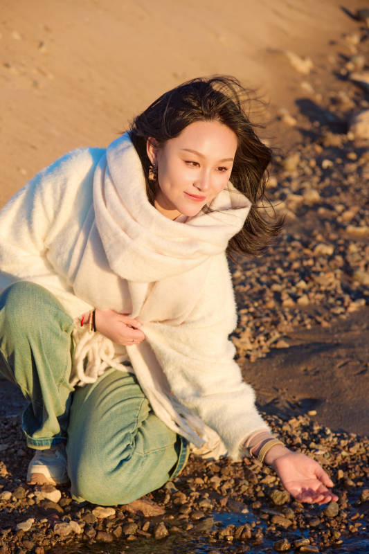 深秋夕阳下在户外河水边的东方女性图片