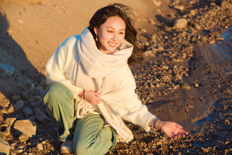 深秋夕阳下在户外河水边的东方女性图片