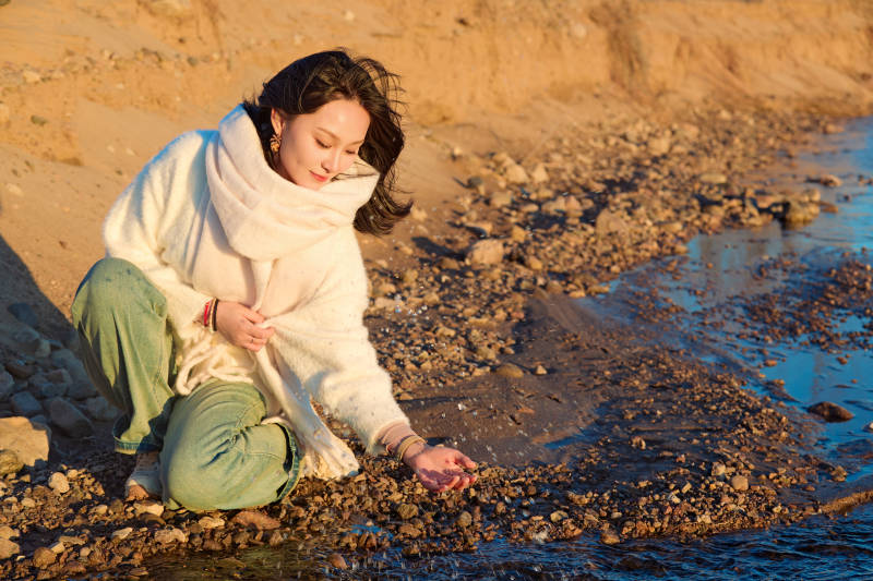 深秋夕阳下在户外河水边的东方女性图片