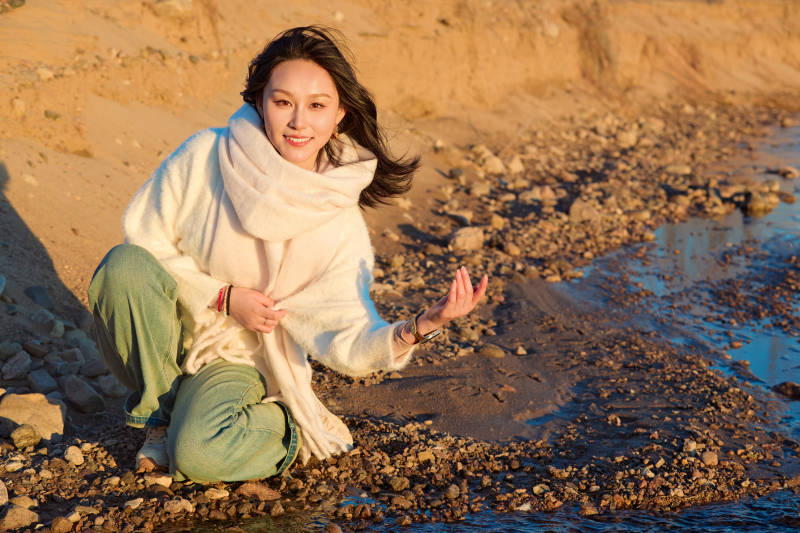 深秋夕阳下在户外河水边的东方女性图片