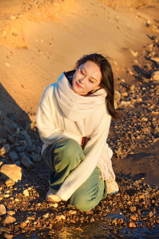 深秋夕阳下在户外河水边的东方女性图片