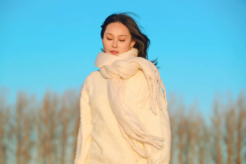 深秋夕阳下在户外河水边的东方女性图片