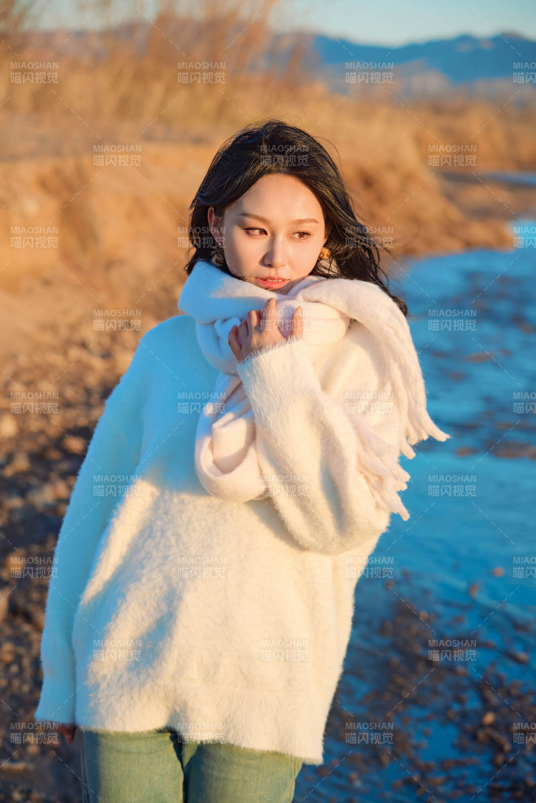 深秋夕阳下在户外河水边的东方女性图片