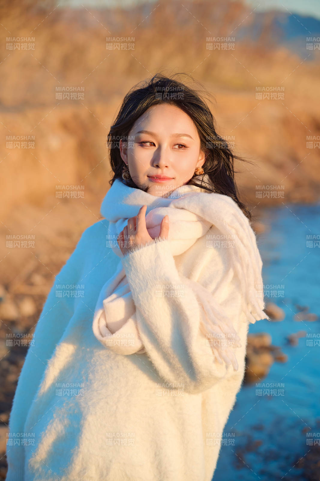 深秋夕阳下在户外河水边的东方女性图片