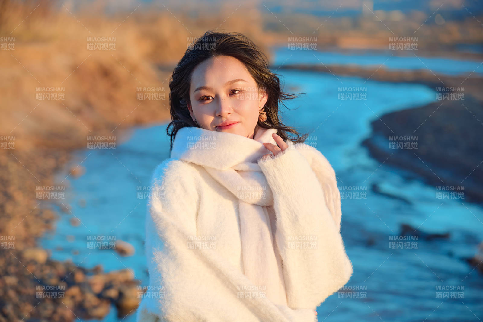 深秋夕阳下在户外河水边的东方女性图片