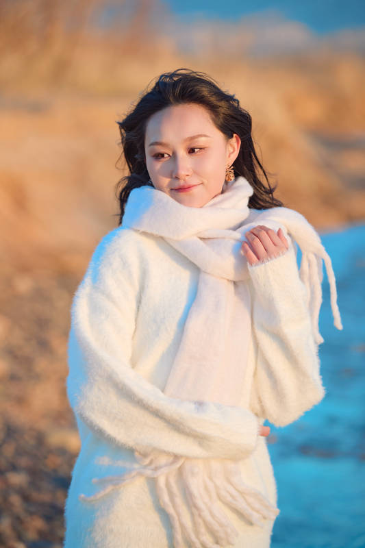 深秋夕阳下在户外河水边的东方女性图片