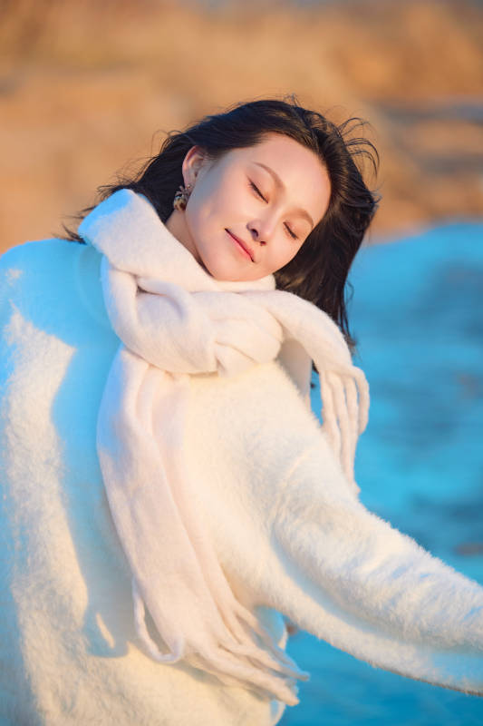 深秋夕阳下在户外河水边的东方女性图片