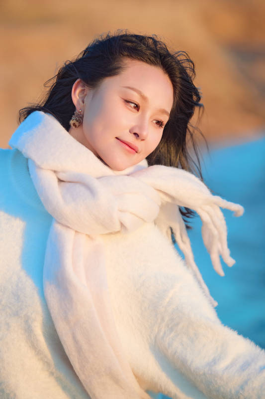 深秋夕阳下在户外河水边的东方女性图片