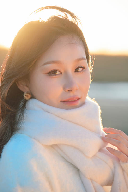 深秋夕阳下在户外河水边的东方女性图片