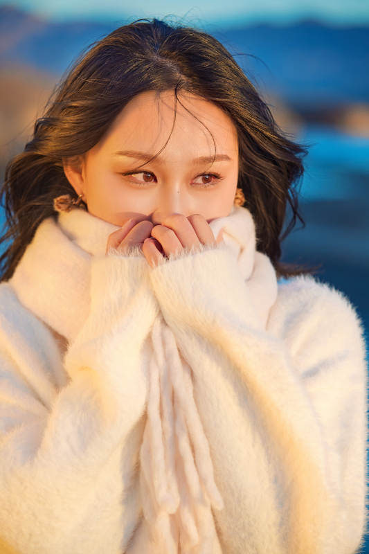 深秋夕阳下在户外河水边的东方女性图片