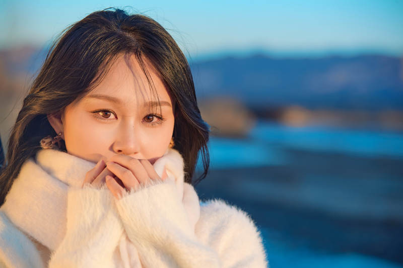 深秋夕阳下在户外河水边的东方女性图片