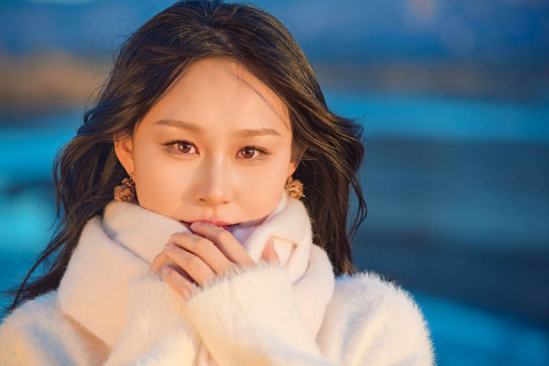 深秋夕阳下在户外河水边的东方女性图片