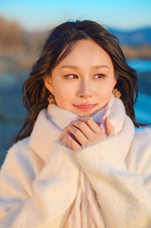 深秋夕阳下在户外河水边的东方女性图片