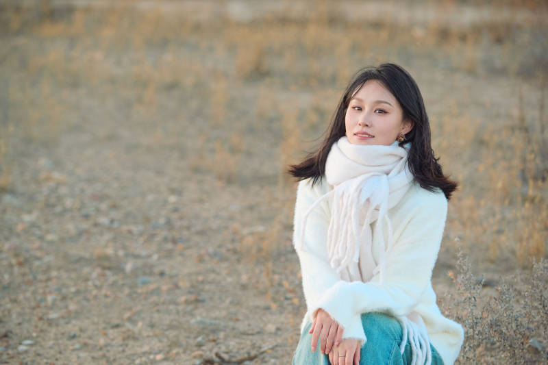 秋天在夕阳下的原野河边拍照的美女图片