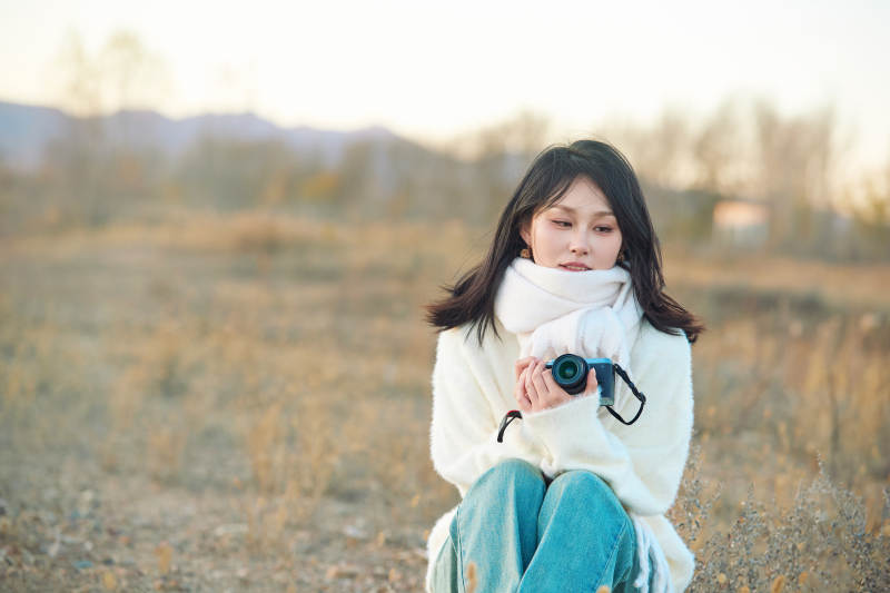 深秋户外手持相机的亚洲女性摄影师图片