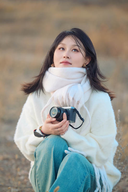 深秋户外手持相机的亚洲女性摄影师图片