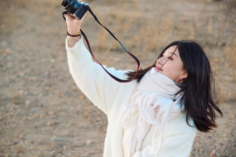 深秋户外手持相机的亚洲女性摄影师图片