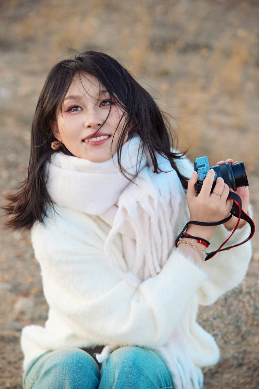 深秋户外手持相机的亚洲女性摄影师图片