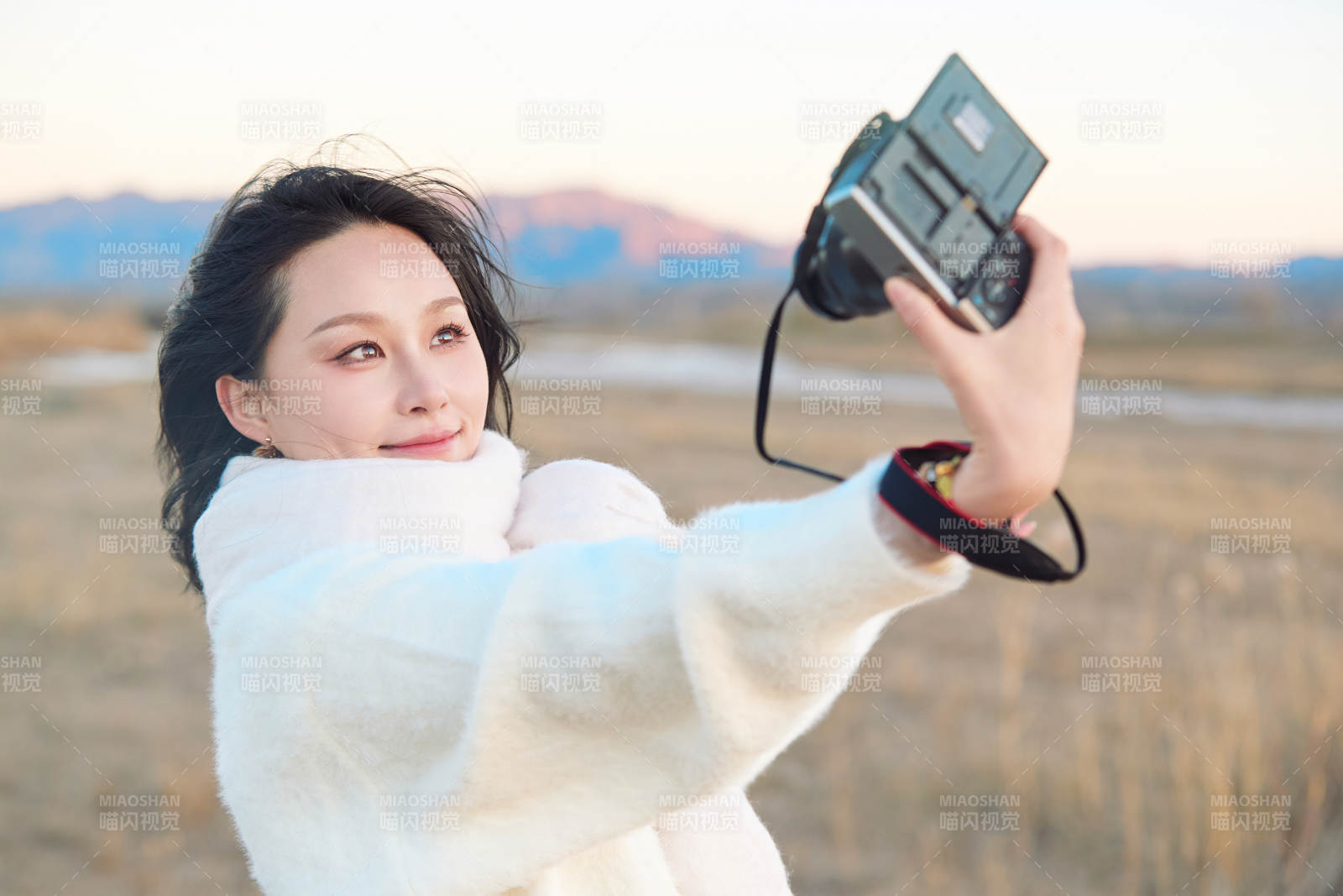 秋天夕阳下手持相机自拍的亚洲美女图片