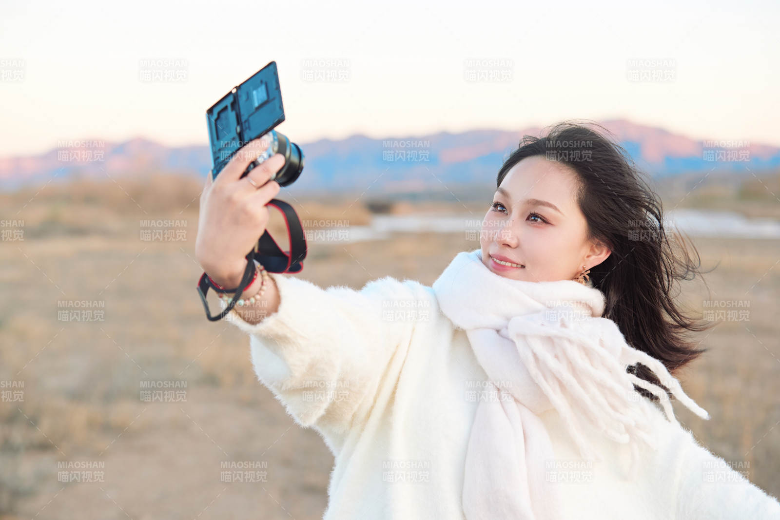 秋天夕阳下手持相机自拍的亚洲美女图片