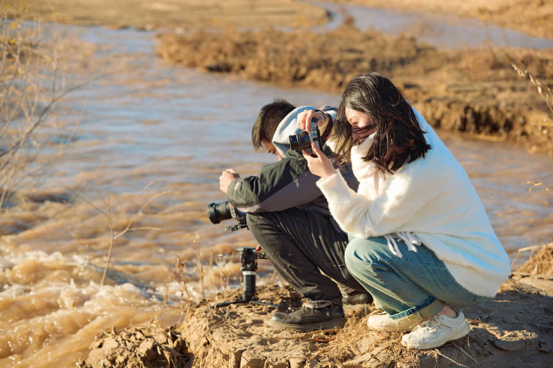 深秋户外进行拍摄的两位亚洲摄影师图片